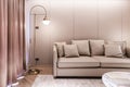 Stylish luxury living room with beige leather sofa, gold stainless wall lamp and wallcovering in the background / luxury interior