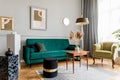 Stylish and luxury living room interior with elegant green velvet armchair, sofa, mock up poster and decoration. Royalty Free Stock Photo