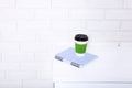 Stylish macro cup of coffee and notebook in office. Selective focus and copy space. Brick wall and workplace business concept. Royalty Free Stock Photo
