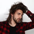 Stylish male model with long hair and beard posing in studio. Modeling, hairstyle, fashion concept. Royalty Free Stock Photo
