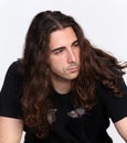 Stylish male model with long wavy hair posing in studio. Trends, style, fashion concept.