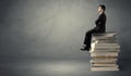 Stylish male seated on books Royalty Free Stock Photo