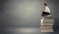 Stylish male seated on books Royalty Free Stock Photo