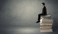 Stylish male seated on books Royalty Free Stock Photo