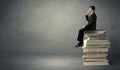 Stylish male seated on books Royalty Free Stock Photo