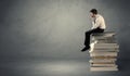 Stylish male seated on books Royalty Free Stock Photo