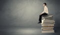 Stylish male seated on books Royalty Free Stock Photo