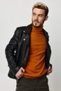 stylish man with beard blond orange sweater pants leather jacket