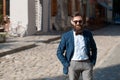 Stylish man with beard wearing a jacket, shirt and bow tie with hands in pockets Royalty Free Stock Photo