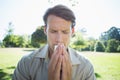 Stylish man blowing his nose in the park Royalty Free Stock Photo