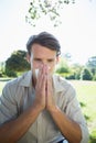 Stylish man blowing his nose in the park Royalty Free Stock Photo