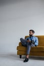 stylish man in blue trendy suit holding smartphone and sitting