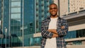 Stylish man in city african american guy young student male in sunglasses wears plaid shirt posing with crossed hands Royalty Free Stock Photo