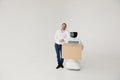 Modern Robotic Technologies. A man communicates with a robot, with cardboard box in hand. Royalty Free Stock Photo