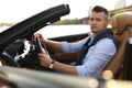 Stylish man driving luxury convertible car outdoors Royalty Free Stock Photo