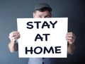 Stylish man holding a sign with the words Stay At Home