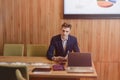 A stylish man in a jacket and shirt sits at the desk with his colleagues and works with documents at office Royalty Free Stock Photo