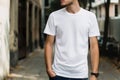 Elegant Man Showcasing a Blank White T-Shirt on an Urban Street During Midday