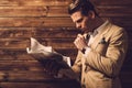 Stylish man with newspaper in rural cottage interior