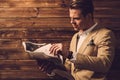 Stylish man with newspaper in rural cottage interior