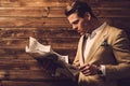 Stylish man with newspaper in rural cottage interior