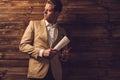 Stylish man with newspaper in rural cottage interior