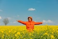 Stylish man in orange jacket in rapeseed field Royalty Free Stock Photo