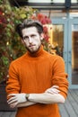 Stylish man in an orange turtleneck, portrait in an urban setting