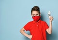 Stylish schoolboy in red medical mask and shirt stands keeping one hand on waist showing crumpled hundred dollar banknote Royalty Free Stock Photo