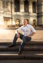 Stylish man sitting on stone stairs at sunset Royalty Free Stock Photo