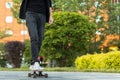 Stylish man skateboarder riding longboard in the city, outdoors, cropped image