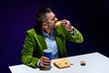 stylish man in velvet jacket with soda drink eating french fries with ketchup at table Royalty Free Stock Photo