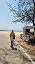 A stylish man walking down a bustling street lined with food carts, enjoying the sights and smells of street food