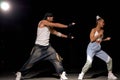 Stylish man and woman dancing hip-hop in casual clothes on black background at dance hall Royalty Free Stock Photo
