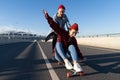 Stylish man and woman skating on longboard enjoy time together. Urban fashion and trendy activity Royalty Free Stock Photo