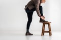 Stylish mature man putting leg on chair while tying shoelaces Royalty Free Stock Photo