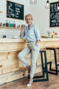 stylish mature woman leaning on chair and looking away