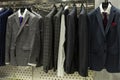 Stylish men`s suits on hangers in the store. Front view. Elegance and fashion Royalty Free Stock Photo