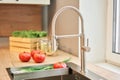 Stylish metallic crane at the kitchen. Sink faucet at the kitchen. Metal crane in close-up photo. Details of the