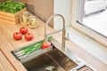 Stylish metallic crane at the kitchen. Sink faucet at the kitchen. Metal crane in close-up photo. Details of the