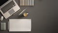 Stylish minimal office table desk. Workspace with laptop, notebook, pencils, coffee cup and sample color palette on dark backgroun