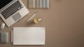 Stylish minimal office table desk. Workspace with laptop, notebook, pencils, coffee cup and sample color palette on dark beige bac