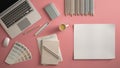 Stylish minimal office table desk. Workspace with laptop, notebook, pencils, coffee cup and sample color palette on pastel pink ba