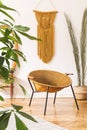 Stylish and minimalist interior of living room with design gold armchair, lamp, poster frames. dressing table with mirror.