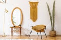 Stylish and minimalist interior of living room with design gold armchair, lamp, poster frames. dressing table with mirror.