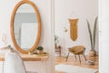 Stylish and minimalist interior of living room with design gold armchair, lamp, poster frames. dressing table with mirror, plants. Royalty Free Stock Photo