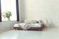 Stylish minimalist loft style bedroom interior with light concrete walls, king size wooden bed with pillows Royalty Free Stock Photo