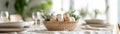 Stylish minimalist table setting features a woven basket filled with decorative eggs and greenery as a centerpiece Royalty Free Stock Photo