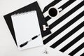 Minimalistic workspace with book, notebook, pencil, cup of coffee on striped black and white background. Flat lay style Top view Royalty Free Stock Photo