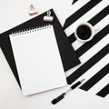 Minimalistic workspace with book, notebook, pencil, cup of coffee on striped black and white background. Flat lay style Top view Royalty Free Stock Photo